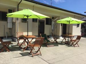 a group of tables and chairs with green umbrellas at Episode1 in Naoshima