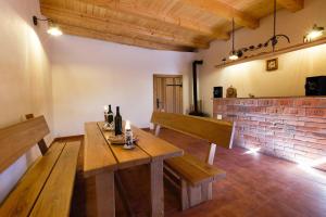 a dining room with a wooden table and a brick wall at Nad Vinnym Sklipkem in Znojmo