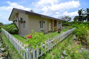 a small house with a white picket fence at Sabah Tea Garden in Ranau