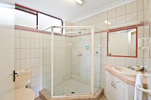 a bathroom with a shower, toilet, sink and tub at Lorne Coachman Inn in Lorne
