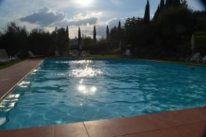 a large pool with blue water in a yard at Casale Rosanna in San Gimignano