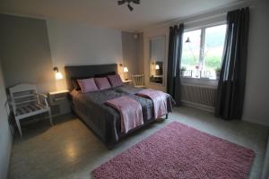 Dormitorio con cama con almohadas rosas y alfombra rosa en Lövås Gård Koppera en Charlottenberg