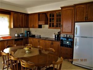 a kitchen with a table and a white refrigerator at Villa Dioni in Coral Bay