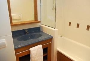 a bathroom with a sink and a mirror and a tub at Village vacances de Valmeinier "Les Angeliers" in Valmeinier