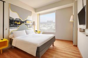 A bed or beds in a room at KIMAYA Braga Bandung by HARRIS