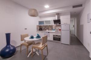 cocina con mesa, sillas y nevera en Silvi Villas by TAM Resorts, en Playa del Inglés