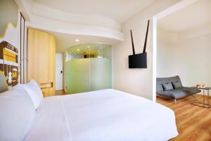 A bed or beds in a room at KIMAYA Braga Bandung by HARRIS