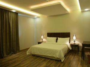 1 dormitorio con 1 cama blanca y 2 lámparas en شقق درر رامه للشقق المخدومة 4, en Riad