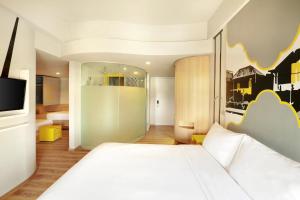 A bed or beds in a room at KIMAYA Braga Bandung by HARRIS