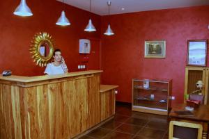 Uma mulher num bar num quarto vermelho. em Hôtel Le Commerce em Modane