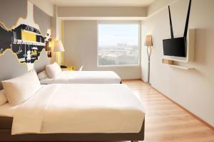 A bed or beds in a room at KIMAYA Braga Bandung by HARRIS