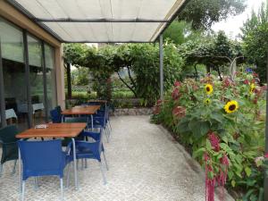 un patio con mesas y sillas y un jardín con girasoles. en Quinta das Delicias, en São Tiaguinho