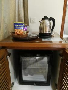 a table with a tea kettle and a bowl of food at Cardogan Hotel in Kuala Lumpur