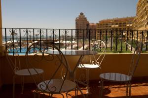balcón con sillas, mesa y piscina en First line apartment, en Alboraya