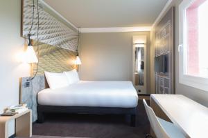 um quarto de hotel com uma cama e uma janela em ibis Genève Aéroport em Genebra