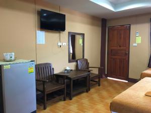 a room with a refrigerator and a table and chairs at Khwanruen Fishing Resort in Ban Chang +83 photos
