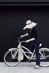 a woman with a hat and a bicycle at The Bower Byron Bay in Byron Bay