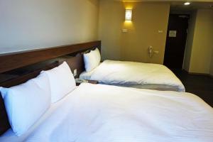 Giường trong phòng chung tại 鼎立安商務旅館 Dinglian Hotel