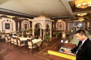 um homem de fato sentado à mesa num restaurante em Hotel Empires em Bhubaneshwar