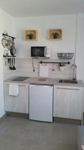 エル・メダノにあるAvenue Studyの白いキャビネットとカウンタートップを備えたキッチン +8枚の写真