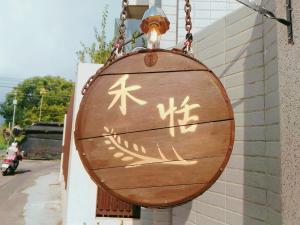 a wooden sign with chinese writing on a wall at He Tian B&B - Cafe & Bar in Puli