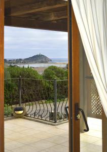 a door to a balcony with a view of the ocean at Sa Tirìa in Chia