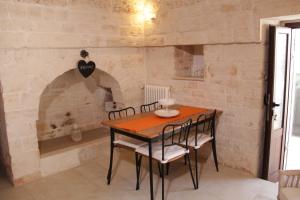 a dining room with a table and a brick wall at il trullo di giada e mattia in Alberobello