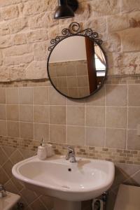 een badkamer met een wastafel en een spiegel bij il trullo di giada e mattia in Alberobello