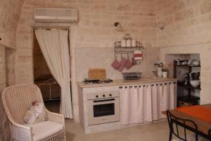 a small kitchen with a stove and a table at il trullo di giada e mattia in Alberobello