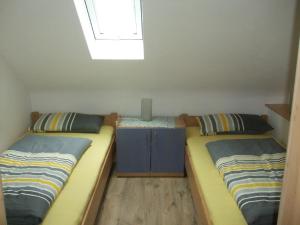 2 Einzelbetten in einem Zimmer mit Fenster in der Unterkunft Ferienwohnung Bockelt in Stadtlauringen