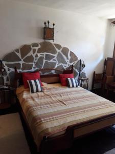 a bedroom with a large bed with a large headboard at Chuchi Guest House 1 in Zlatna Panega