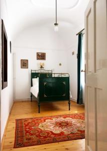 ein Schlafzimmer mit einem Bett und einem Teppich in der Unterkunft Igmándy kúria in Nagybajom