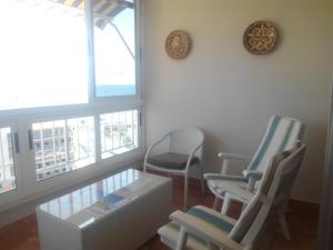 ビリャホヨサにあるSainvi 39Cの椅子2脚、テーブル、窓が備わる客室です。
