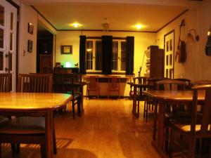 uma sala de jantar com mesas e cadeiras de madeira em Madarao Mountain Lodge em Iiyama