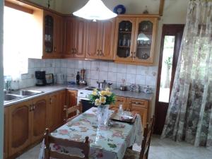 a kitchen with a table with a vase of flowers on it at Gramvousa's Filoxenia Apartment in Kissamos