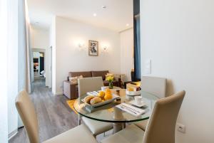 comedor y sala de estar con mesa de cristal y sillas en LETHESHOME Apartments en Oporto