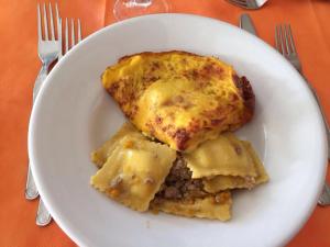 a white plate with a plate of food on a table at Hotel Madrid in Riccione +29 photos