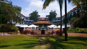 a gazebo with tables and umbrellas next to a building at Lanka Princess All Inclusive Hotel in Bentota