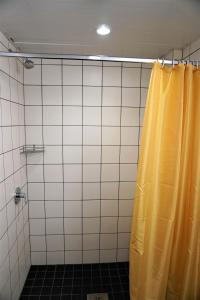 een douche met een geel douchegordijn in de badkamer bij Downtown Hostel in Tartu