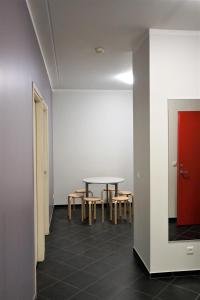 een kamer met een tafel en stoelen en een rode deur bij Downtown Hostel in Tartu