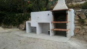 a white oven sitting next to a stone wall at Cueva Rural La Noguera in Pegalajar +3 photos