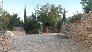 a stone walkway with a stone wall and benches at Cueva Rural La Noguera in Pegalajar
