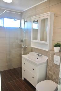 uma casa de banho com um WC, um lavatório e um chuveiro em Lynghagi House em Vegamót
