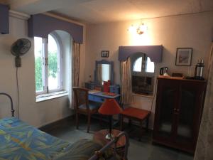 1 dormitorio con cama, escritorio y ventana en Udai Bilas Palace, en Dūngarpur