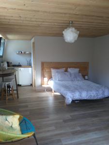 ein Schlafzimmer mit einem großen Bett und einer Holzdecke in der Unterkunft Le chalet du Lac in Doussard