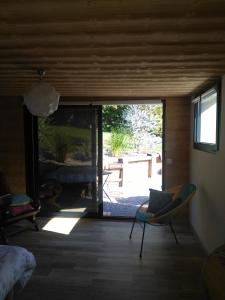 Habitación con una gran puerta corredera de cristal y patio. en Le chalet du Lac, en Doussard
