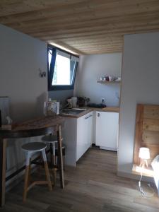 eine Küche mit weißen Schränken, einem Tisch und einem Fenster in der Unterkunft Le chalet du Lac in Doussard