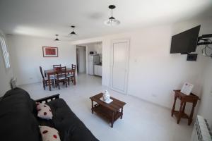 a living room with a black couch and a table at Aparthotel Aldea Termal in Copahue