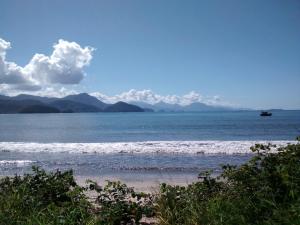 - une vue sur la plage avec un bateau dans l'eau dans l'établissement Ubatuba Surf Suites, à Ubatuba