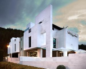a white building with an umbrella in front of it at Hotel Playa Ribera in Suances